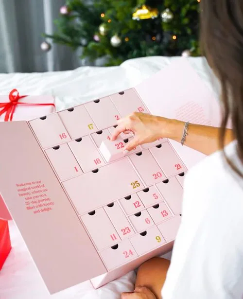 Boozyshop adventskalender 2025 waar een vrouw een vakje van openmaakt